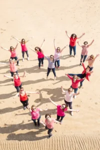 La future mariée et ses amies forment un coeur sur le sable