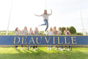 future mariée qui saute devant un panneau Deauville
