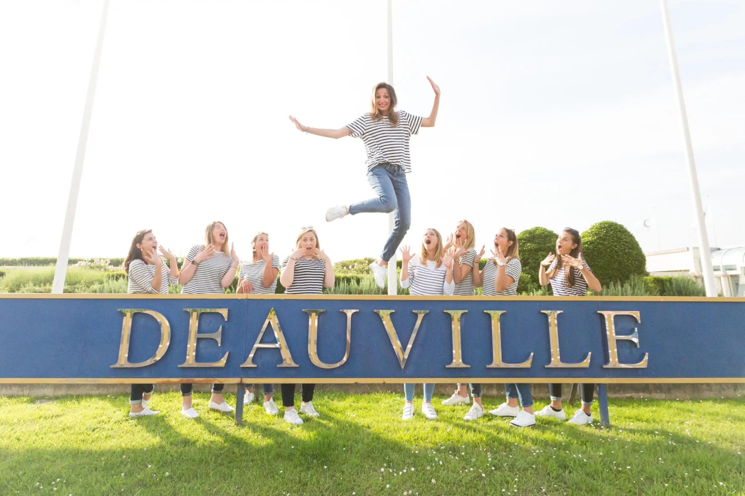 future mariée qui saute devant un panneau Deauville