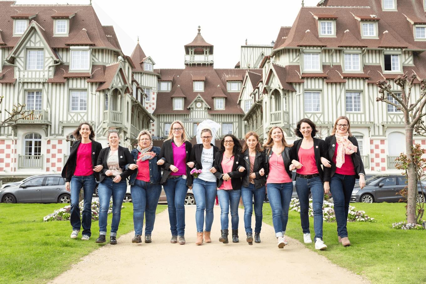 Groupe d'amies souriantes marchant devant le célèbre Normandy de Deauville lors d'un EVJF