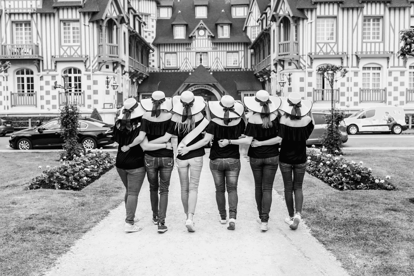 Promenade complice entre amies à Deauville pendant une séance photo. En noir et blanc.