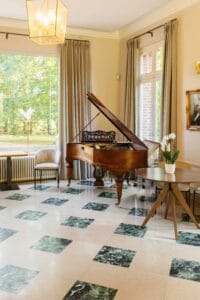 Élégante salle de réception avec son piano à queue au rez-de-chaussée du Château de la Bribourdière.