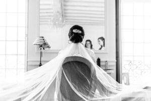 Portrait noir et blanc de la mariée de dos face au miroir pendant ses préparatifs au Havre.