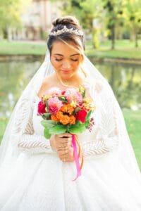 La mariée, les yeux baissés, dévoile son voile et son diadème étincelant.