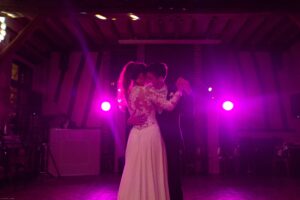 Ouverture de bal romantique des mariés dans une superbe grange en pierres illuminée.
