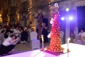 Pièce montée traditionnelle de mariage en choux et nougatine illuminée par des fontaines lumineuses.