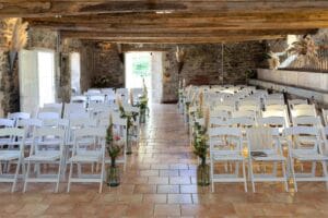 Salle de cérémonie laïque décorée avec des chaises blanches et pampas au Moulin de Bully.