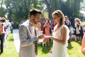 Échange des alliances sous le soleil de Normandie lors d'un mariage champêtre près de Honfleur.