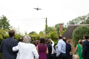Surprise pour les invités qui regardent un avion passer dans le ciel lors du cocktail dans les jardins.