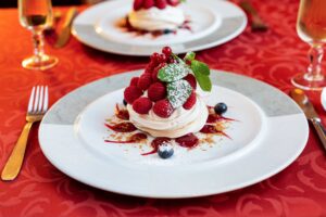 Pavlova aux fruits rouges et menthe fraîche, photographie de dessert haute définition.