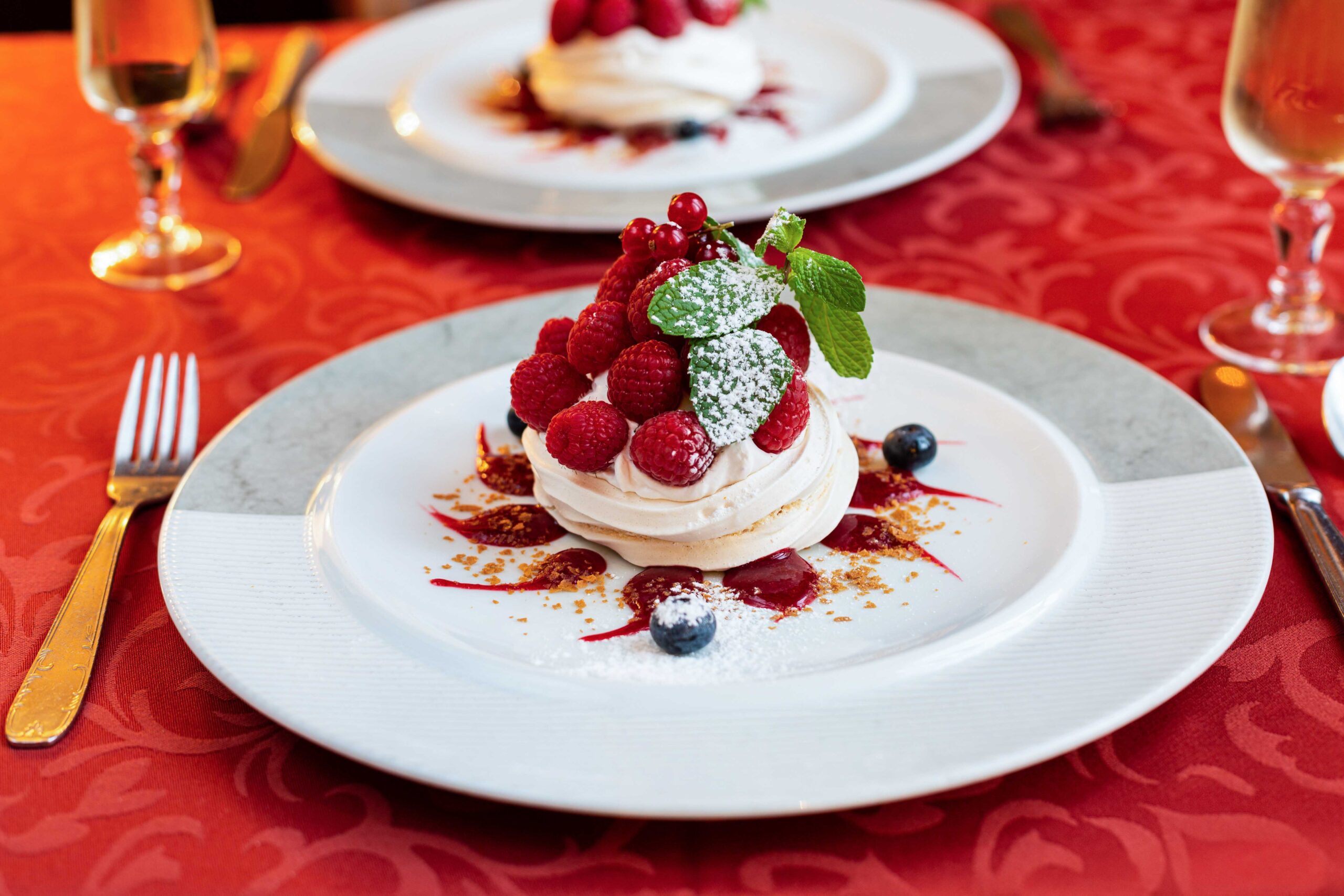 Pavlova aux fruits rouges et menthe fraîche, photographie de dessert haute définition.