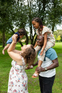 Rires et complicité : une famille joue ensemble dans un parc verdoyant photographiée par M2 Photographie