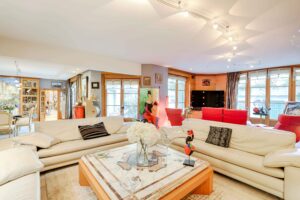Grand salon lumineux avec cuisine ouverte, photographie immobilière pour mise en vente.