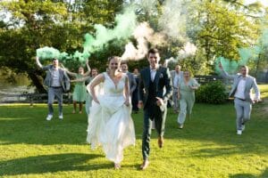 Course amusante des mariés et de leurs témoins avec des fumigènes verts près de Deauville.