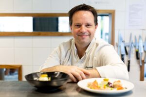 Chef cuisinier présentant son plat lors d'un reportage métier en Normandie.