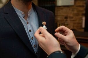 Boutonnière de marié insolite personnalisée avec une figurine R2-D2 et fleurs séchées.