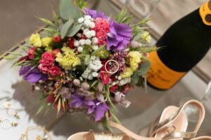 Alliance de mariage en or posée au cœur d'un bouquet de fleurs sauvages colorées.
