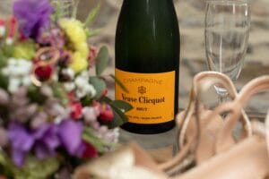 Bouteille de champagne Veuve Clicquot et bouquet de la mariée lors des préparatifs.