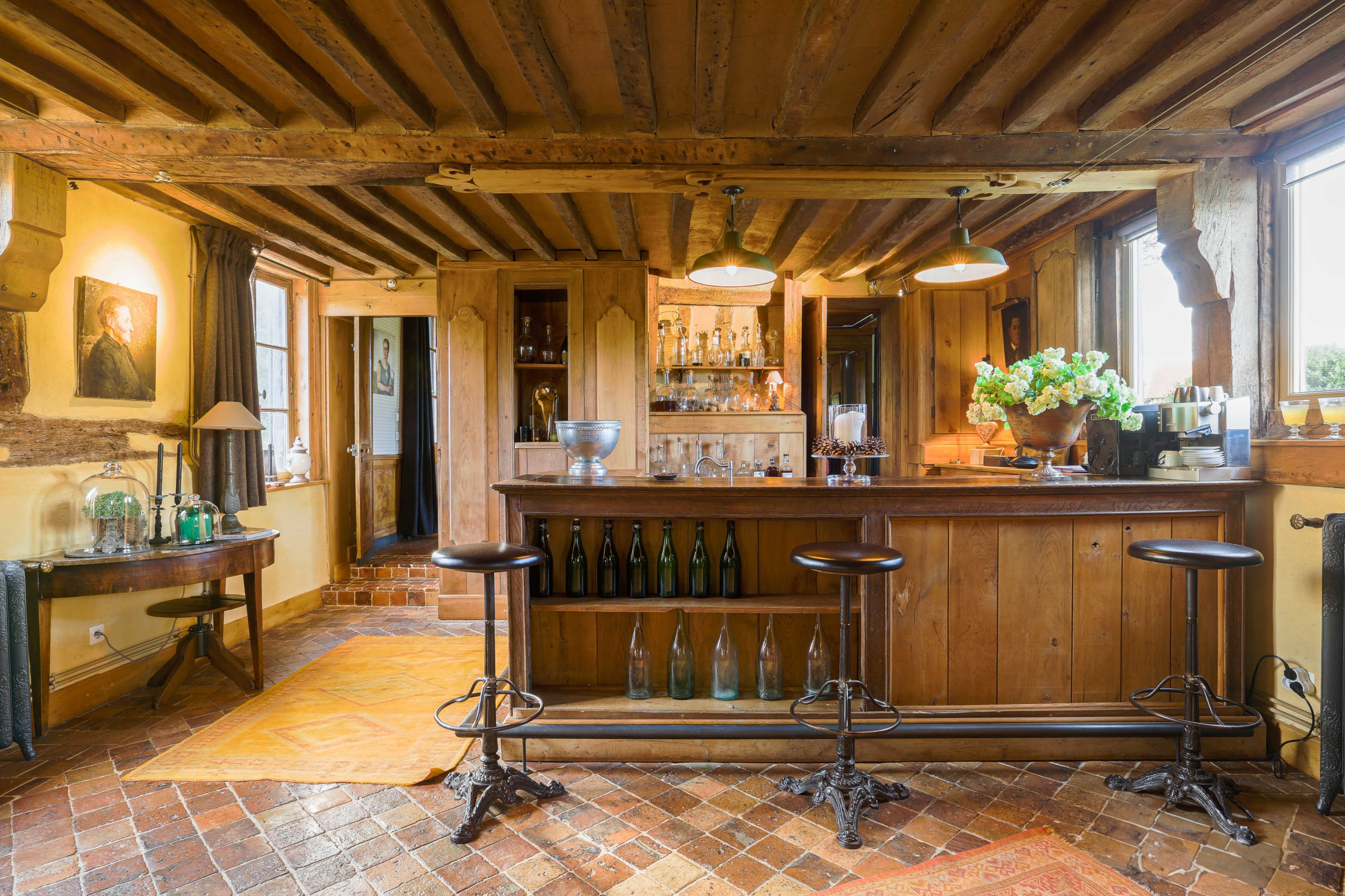Photographie d'architecture d'un espace bar lounge avec boiseries et poutres apparentes.