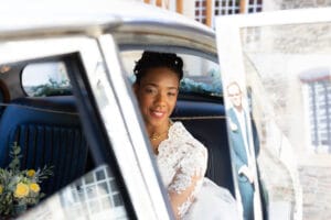 La mariée arrive au Moulin de Bully à bord d'une voiture ancienne décorée de fleurs.