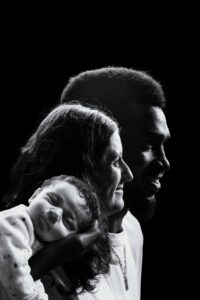 Portrait artistique de profil en noir et blanc d'une famille et leur bébé, photographe Honfleur.