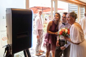 Groupe d'invités souriants prenant la pose devant notre borne selfie lors d'un mariage, location de photobooth à Honfleur et Deauville.