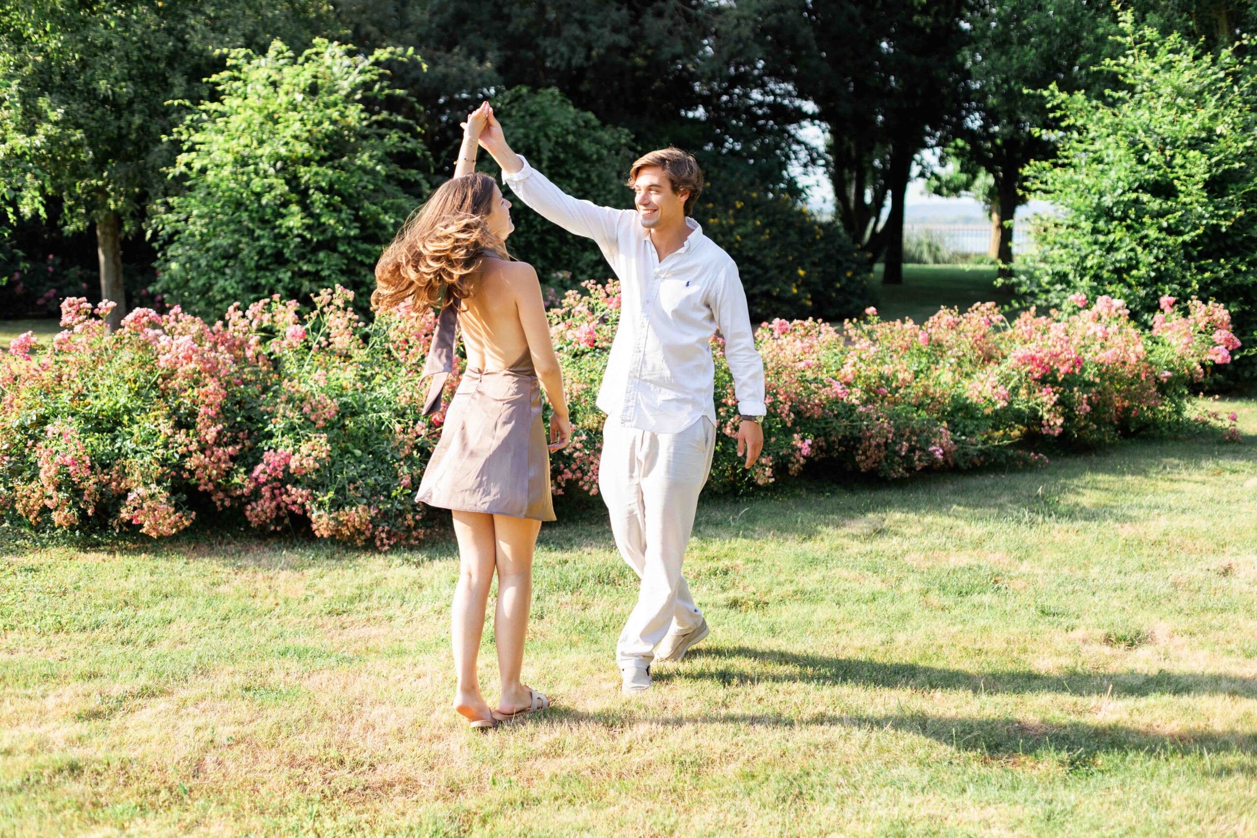 Photographe de couple en Normandie : moment de grande complicité et rires dans un jardin fleuri.