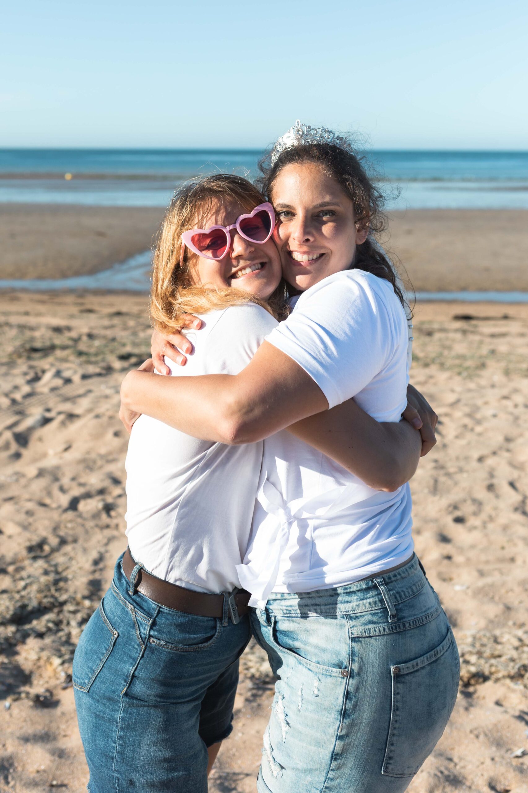 Moment de tendresse entre la mariée et son amie sur la plage de Deauville.